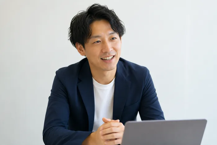 ノートパソコンを前に、笑顔で話す事業側のWeb担当の様子